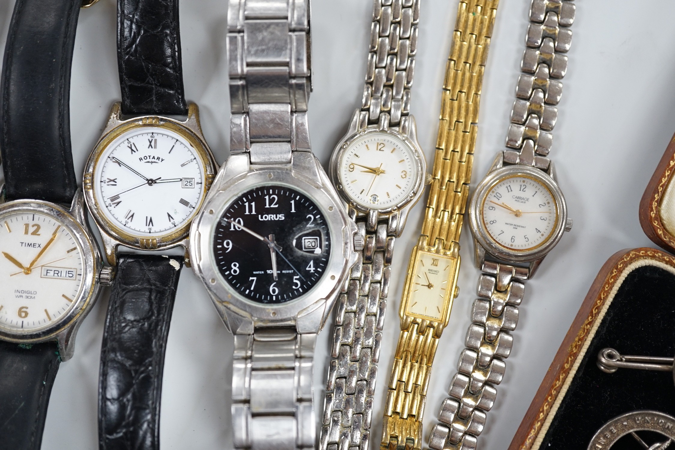 Seven assorted modern wrist watches including Pulsar and Rotary, a 9ct and 'silver' eternity ring, a case amber cigarette holder and two white metal brooches, including one with enamel.